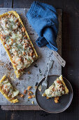 Slice of tart with pumpkin and Emmental cheese on dish with fork placed on tray