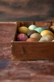 Gefärbte Eier in Holzkiste