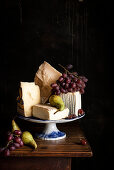 An arrangement of cheese with grapes and pears