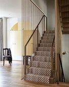 Lattice-patterned carpet on stairs with metal handrail