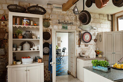 Dresser in rustic country-house kitchen with stone wall