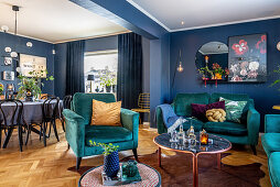 Petrol-blue sofa set in open-plan interior with blue wall