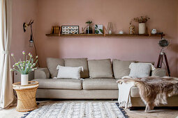 Chaise couch in living room with pastel-pink walls