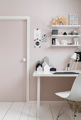 Shell chair at desk in child's bedroom in pink and white