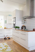 Bright, white, spacious kitchen with wooden floor