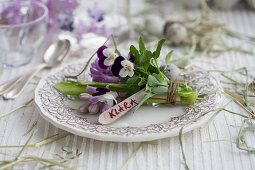 Posy of hyacinths and violas with name tag decorating plate