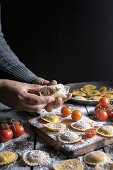 Selbstgemachte Ravioli mit Parmesan, Tomaten und Basilikum (Italien)