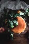 A layered apple cake with a caramel topping and apple leaves