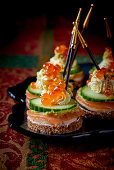 Black bread canapés with cucumber and salmon caviar