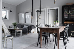 Lounge area, black display cabinet and dining table in grey interior