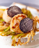 Scallops with truffles on a braised salad, close-up
