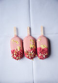 Drei rosa Popsicles mit Blattgold