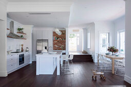 Dining table in the bay window and open kitchen with dark wooden floor