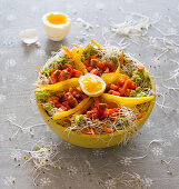 A bowl with sweet potatoes, peppers, guacamole, bean sprouts and egg