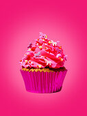 A cupcake against a pink background