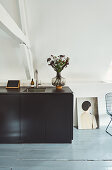 Simple black kitchen counter in attic room with wood-beamed ceiling