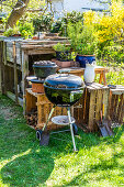 A charcoal barbecue and a Dutch oven in a garden