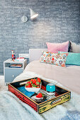 Strawberries on brightly coloured tray on bed in bedroom