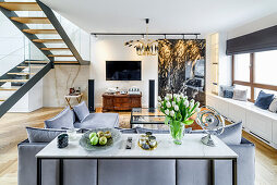 Console table against back of sofa in elegant lounge with window seats