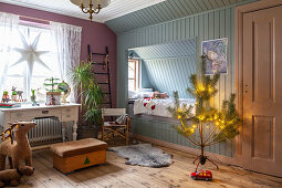 Alkovenbett und nostalgischer Schreibtisch in weihnachtlich dekoriertem Kinderzimmer