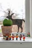 Festive arrangement of potted succulent, reindeer and gnome musicians on windowsill