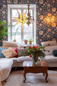 White corner sofa in festively decorated living room with William Morris wallpaper