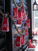 Advent calendar made from red tea packets hung from garland of nuts