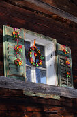 Handmade willow wreaths with felt leaves and felt flowers hung on window