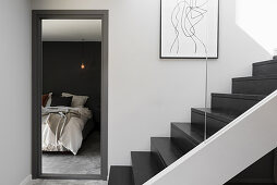 Doorway to bedroom next to staircase in black and grey