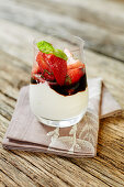 A cream dessert with strawberries and basil