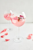 Gin and tonic cocktail with rose infused tonic and frozen roses