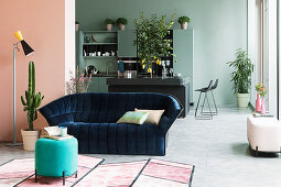 Dark blue velvet sofa in loft apartment with walls in pastel tones