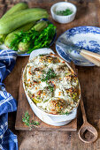 Stuffed zucchini with sour cream in a baking dish