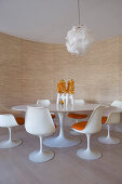 Round, white, classic Tulip table and matching chairs in dining area