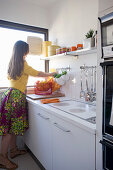 Woman in white fitted kitchen