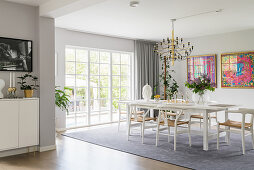 Designerstühle am weißen Tisch im eleganten Esszimmer