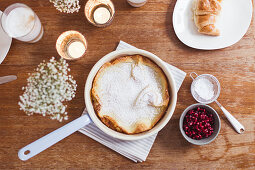 Oven baked pancake with powdered sugar and pomegranate seeds
