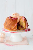 Raspberry gugelhupf with cotton candy, sliced on a cake stand