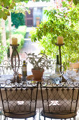 Table set with plant, candlesticks, jug of water and olive oil