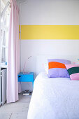 Weiße Schlafzimmerwand mit Farkakzent durch horizontalen gelben Streifen