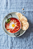 Shakshuka with smoked peppers, harissa and unleavened bread (Levant cuisine)