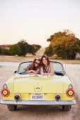 Zwei Freundinnen in gelbem Cabrio