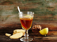 Canadian apple punch with whisky, cinnamon, lemon and biscuits on a wooden surface