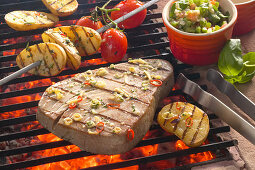 Tuna steak and vegetables on a grill with a pepper salsa