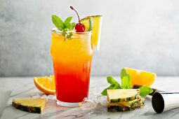 Tequila sunrise cocktail with pineapple and orange