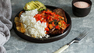 El Bistec a la Criolla - colombian beef steak with tomatoes sauce, rice, avocado, bananas fries