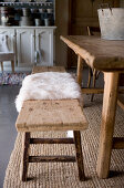 Fur rug on rustic wooden bench at dining table