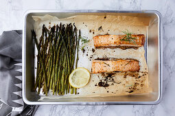 Salmon and asparagus baked in the oven, seasoned with olive oil and rosemary