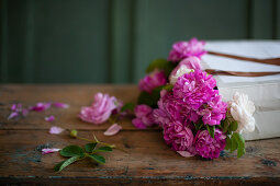 Pink roses in paper bag on wooden table