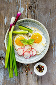 Homemade fried eggs in a plate, served with fresh vegetables